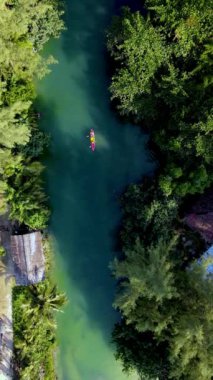 Koh Chang, Tayland 'ın dingin turkuaz sularında canlı kayakçılar yemyeşil çevrede gezinirken kürek çekin. Bu tropikal cennette doğa güzelliğini tecrübe eder..