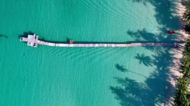 Koh Kood Adası Tayland 'ın nefes kesen manzarasını kristal berrak sularıyla ve sallanan palmiye ağaçları arasında yuva yapmış uzun ahşap iskelesiyle keşfedin..