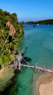 Koh Kood, Tayland 'ın nefes kesici güzelliğini keşfedin. Gök mavisi sular el değmemiş kıyılara nazikçe yaklaşırken. Rüzgarda sallanan gür palmiye ağaçları, sakin bir tropikal kaçış yaratır..