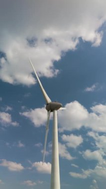 Dev rüzgar türbinleri Hollanda 'daki kabarık bulutlara karşı zarifçe dönüyor. Bu büyüleyici görüntü yeşil enerjiye ve sürdürülebilirliğe olan bağlılığı vurguluyor.