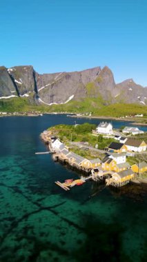 Çarpıcı dağların arasına yerleşmiş renkli bir köy, suyun yanında gelişiyor. Güneş doğayı aydınlatırken tekneler yavaşça sallanıyor, doğal güzellik ve sükunet sergiliyor. Sakrisoy Lofoten Norveç