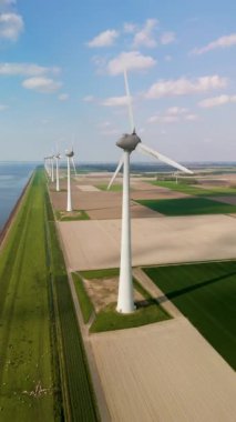 Hollanda 'nın sakin manzarasını deneyin. Görkemli yel değirmeni türbinlerinin rüzgar gücünden faydalandığı. Bu yapılar yeşil enerjiyi sembolize ediyor, resim alanlarında dimdik duruyorlar..