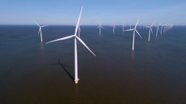 Hollanda 'nın sakin sularında dimdik duran rüzgar türbinlerinin çarpıcı görüntüsünü keşfedin. Rüzgarın gücünü yenilenebilir enerji üretmek için kullanın..