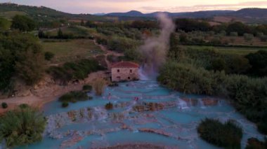İtalya 'nın nefes kesici güzelliğine tanık olun. Buharı tüten su, alacakaranlıkta yemyeşil manzaraların arasında fışkırıyor. Isı yayları ya da Satürn 'ün sıcak havuzları, Toskana