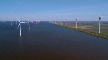 Hollanda 'daki geniş gökyüzüne karşı ayakta duran sayısız yel değirmeni türbininin nefes kesici görüntüsünü deneyimleyin..