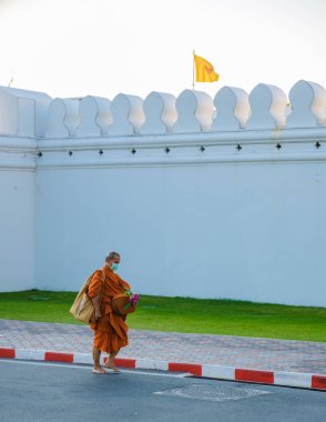 10 Ocak 2025 'te Bangkok Tayland' da canlı turuncu bornozlar giyen bir keşiş sessizce yürüyor.