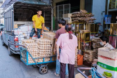 10 Ocak 2025 'te Bangkok Tayland' da satıcılar yorulmadan bir kamyondan taze ürünleri indiriyor. Hareketli etkinlik, başka bir yoğun güne hazırlanan yerel işletmeler için hayati önem taşıyor..