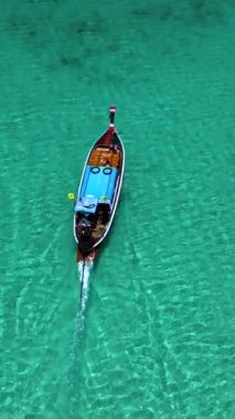 Geleneksel bir tekne el değmemiş turkuaz sularda süzülürken Koh Kradan, Tayland 'ın huzurlu güzelliğini tecrübe edin..