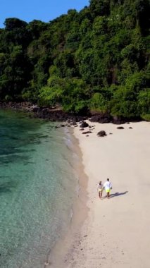 Parlak mavi gökyüzünün altındaki kıyı şeridini verimli yeşillikle çevreleyen Koh Kradan 'ın büyüleyici beyaz kumları boyunca el ele dolaşırlar. Sakin atmosfer rahatlamayı ve macerayı davet eder..