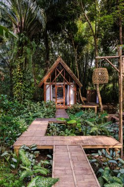 Canlı yeşilliklerin arasına yerleşmiş büyüleyici bir bambu inzivası yolcuları gevşemeye davet ediyor. Tahta yollar tropikal bitkilerin arasından geçip sakin bir kaçış yaratıyor. Orman yağmur ormanlarında ağaç ev