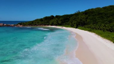 Yumuşak kumlu plajları ve canlı mavi sularıyla Seyşeller 'in el değmemiş güzelliğini keşfedin. Mükemmel güneşli bir günde bu adanın sükunetini ve doğal ihtişamını hissedin..