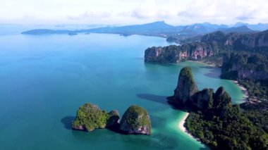 Railay plajı Krabi Tayland 'ın muhteşem sahil şeridine tanık olun. Yeşilliğin berrak sularla buluştuğu, doğa severler ve maceracılar için bir cennet yarattığı yer..