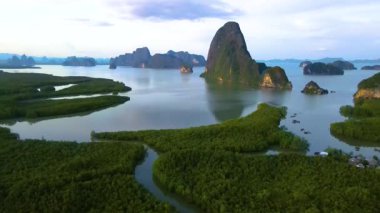 Güneş batarken Phang nga Körfezi Tayland 'ın göz kamaştırıcı manzarasına tanık olun, yemyeşil ve yüksek kaya oluşumları üzerine altın bir parıltı saçıyor. Doğanın güzelliği her karede ortaya çıkar..
