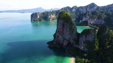 Railay Beach Krabi Tayland 'ın nefes kesici güzelliğini yukarıdan görün. Canlı turkuaz sular görkemli kireçtaşı kayalıklarıyla buluşarak, ziyaretçileri cezbeden çarpıcı bir manzara yaratıyor..