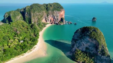 Turkuaz suların altın kumla buluştuğu Krabi Tayland 'ın sakin kıyılarını ve bereketli manzaralarını deneyin. Railay Sahili 'nin insansız hava görüntüsü