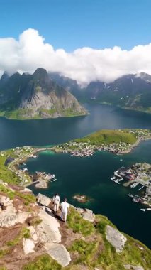 Sersemletici dağlar, dingin fiyortları, bereketli manzaraları ve Norveç 'in büyüleyici kıyı köylerini ortaya çıkaran panoramik manzaraları keşfetmek, Reinebringen Lofoten Norveç' te yürüyüş yapan bir çift