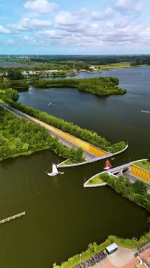 Veluwemeer Aqueduct Hollanda, güzel tasarlanmış bir yapıda karanın suyla buluştuğu yer. Yeşillik ve dingin manzaralarla çevrili yol üzerinde gezinen tekneler..