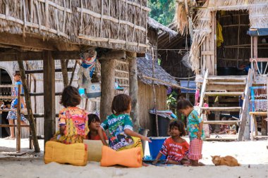 Phangnga, Tayland, 21 Ocak 2025, Surin Adası 'nda, bir grup Moken çocuğu, geleneksel kulübelerle çevrili kumlu sahilde yaratıcı bir oyun sergilerken, kaygısız öğleden sonralarının tadını çıkarıyorlar..