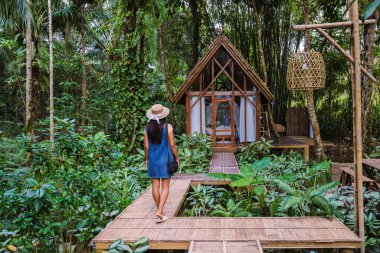 Huzuru kucaklayan bir gezgin yağmur ormanlarında canlı yapraklar ve tropikal bitkilerle kaplı büyüleyici bir ahşap inzivaya çekiliyor. Rahatlamak ve keşfetmek için mükemmel bir kaçış..