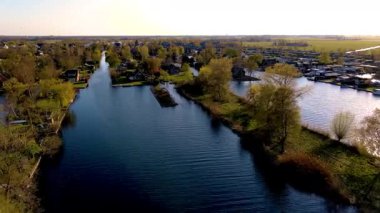 Hollanda 'da canlı ağaçlarla çevrili sakin nehirlerin ve resimli evlerin geniş manzaraları barışçıl bir atmosfer yaratıyor. Vinkeveense Plassen Hollanda