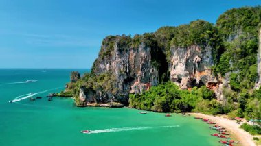 Tonsai Krabi, Tayland 'ın nefes kesici manzarasını deneyin, canlı turkuaz suların yemyeşil kayalıklarla buluştuğu yer. Bu tropikal cennetin güzelliğini keşfedin. Tekneler huzurlu körfezde süzülürken..