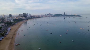 Pattaya Tayland 'ın sakin sularını ve nazik dalgalarını hissedin. Bu çarpıcı kıyı manzarası, balıkçıların şafak vakti şehrin bir zemininin sabah ışığında usulca yükseldiğini gösteriyor..