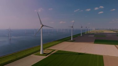 Uçsuz bucaksız yel değirmeni türbinleri, Hollanda 'nın ufkunda dimdik ayakta duruyor. Okyanustaki yel değirmeni parkı, yel değirmeni türbinlerinin yeşil enerji üreten hava aracı görüntüsü.