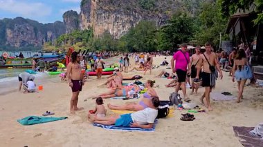 Krabi Tayland 2 Şubat 2025, Ziyaretçiler kumlu sahillerde güneşli bir günün tadını çıkarıyorlar. Sahile gidenler güneşlenirler, yüzerler, Railay sahilinde kalabalık bir gün geçirirler.
