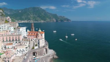 İtalya 'nın Amalfi kentindeki kayalıklara yapışan renkli binaların ve mavi sularda süzülen teknelerin çarpıcı güzelliğini görün. Bu huzurlu sahil kasabası mükemmel bir yaz kaçışı sunuyor..