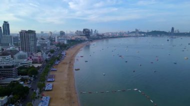 Pattaya Sahili 'nin sakin manzarasının tadını çıkarın. Altın kumları, yumuşak dalgaları ve arka planda hareketli şehir siluetini sergiliyor. Bu canlı varış yerinin güzelliğini keşfedin.