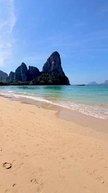 Railay plajı Krabi Tayland 'ın nefes kesici güzelliği yumuşak kumlu plajları ve çarpıcı kaya oluşumlarıyla. Sakin turkuaz sular bu tropikal cennette rahatlamaya ve keşfetmeye davetiye çıkarır..