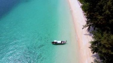 Tayland 'daki Koh Kradan' ın huzur dolu cennetini keşfedin. Yumuşak kumların rahatlatıcı dalgalarla buluştuğu yeri. Bereketli yeşilliklerle çevrili turkuaz kıyı şeridi boyunca huzurlu bir tekne yolculuğunun tadını çıkarın..