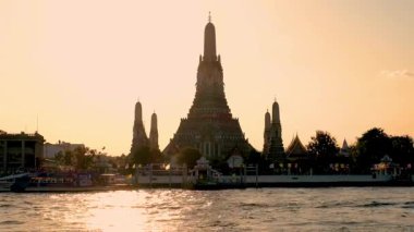 Wat Arun, Bangkok 'ta altın bir günbatımına görkemli bir şekilde karşı duruyor. Karmaşık mimarisini ve dingin güzelliğini sergiliyor. Nehir canlı renkleri yansıtır, nefes kesici bir manzara yaratır..