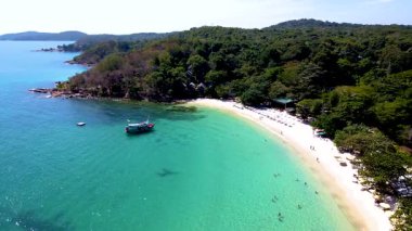 Ziyaretçiler Koh Samet Adası Tayland 'daki günlerinin tadını çıkarırken, yumuşak dalgalar kıyıda hafifçe tur atıyor. Parlak güneş ışığı çarpıcı manzarayı aydınlatır, yemyeşil ve davetkar plajları sergiler..