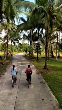 İki binicinin uzun palmiye ağaçlarının gölgesinde pedal çevirmesi gibi sakin bir bisiklet macerası Chumphon, Tayland 'da serin bir yolda başlar. Bereketli manzara, keşfi ve eğlenceyi davet eder..