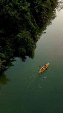 Kürekçiler, tropik yeşilliklerle çevrili Tayland 'daki yemyeşil kanallarda gezinirler. Sakin sular doğanın güzelliğini yansıtıyor. Chumphon yağmur ormanlarındaki cennete sakin bir kaçış yaratıyor.
