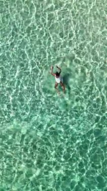 Tayland 'ın ışıldayan turkuaz sularında bireysel olarak yüzen sakin bir an. Güneş ışığı yüzeyde dans eder, güzel ve sakin bir atmosfer yaratır Koh Munnork Adası