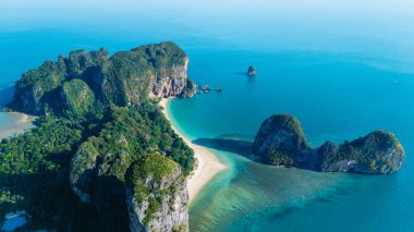 Bir hava manzarası Tayland, Krabi 'deki Railay Sahili' nin nefes kesici güzelliğini gözler önüne seriyor. Zümrüt sularının altın kıyılarda dolaştığı, dramatik kireçtaşı kayalıkları ve canlı yeşilliklerle çevrili..