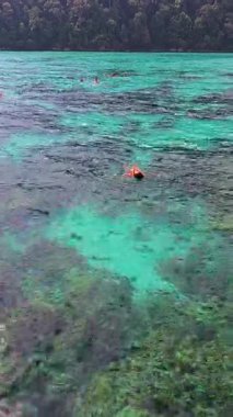 Tayland 'daki Surin Adası' nın nefes kesici güzelliğini keşfedin. Berrak turkuaz sular maceraperest yüzücüleri güneşin altındaki canlı mercan resiflerini ve deniz yaşamını keşfetmeye davet eder..