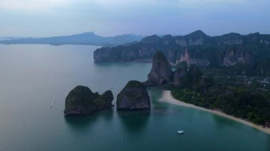 Muhteşem kayalıkların sakin sularla buluştuğu Railay Beach Krabi Tayland 'ın nefes kesici kıyı manzarasını deneyin. Ziyaretçiler bu tropikal cennetin güzelliğinin tadını çıkarıyorlar. Rahatlamak için mükemmel..