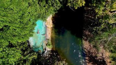 Kendini, kristal berrak suların yemyeşil ile buluştuğu el değmemiş Tayland ormanının huzurlu güzelliğine daldır. Yağmur ormanlarındaki yüzme havuzunun en üst manzarası. 