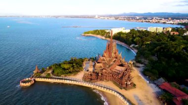 Pattaya, Tayland 'da denizin kıyısında dimdik duran görkemli Doğruluk Mabedi' ne tanık olun. Karmaşık ahşap heykeller ve mimari harikalar Tayland işçiliğini sıcak güneşin altında sergiliyor..