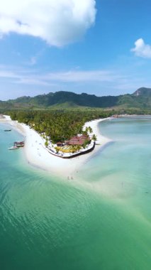 Koh Mook Adası 'nın çarpıcı sahil şeridini keşfedin. Bereketli yeşillik yumuşak kumlu kıyılarla buluşuyor. Tekneler berrak turkuaz sularda süzülüyor. Güneşin altında rahatlamaya ve maceraya davetiye çıkarıyorlar..