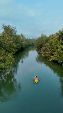 Chumphon Tayland 'da sakin kanallar boyunca seyahat et. Canlı yeşillikler ve zengin tropikal yeşilliklerle çevrili sakin sularda gezinen yalnız bir kanocu huzur ve macera hissi uyandırıyor..