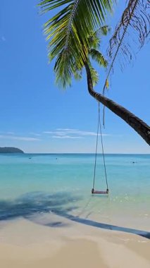 Koh Kood Tayland 'da kristal berrak suları ve palmiye ağacından sallanan sakin bir salıncakla büyüleyici bir tropikal plaj keşfedin. Sahne, rahatlama ve doğal güzelliği somutlaştırır..