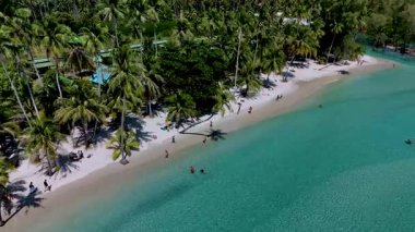 Kendinizi Koh Kood Tayland 'ın kumlu sahillerine daldırın. Palmiye ağaçları usulca sallansın. Güneş banyosu yapanlar güneşlenirken, diğerleri turkuaz sularda yüzüyor..