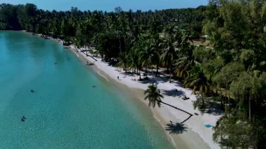Tropik cennet, turkuaz berrak suların kumlu bir sahile vuruşuyla bekliyor. Güneş banyosu yaparken palmiye ağaçları yavaşça sallanıyor ve Koh Kood Tayland 'ın sakin sahil şeridinin tadını çıkarıyor..