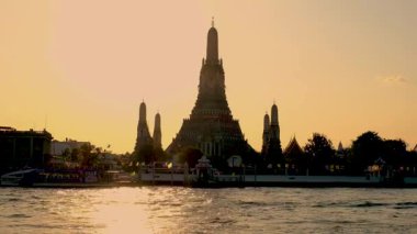 Wat Arun 'un güzel bir manzarası, aynı zamanda Şafak Tapınağı olarak da bilinir, Tayland' da canlı bir günbatımına karşı siluet.