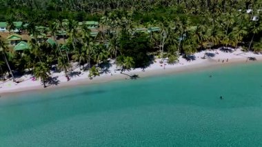 Koh Kood Tayland kıyılarının berrak suları ve sallanan palmiye ağaçları ile nefes kesici güzelliğini keşfedin. Güneş banyosu yapanlar ve yüzücüler, kıyı boyunca sıcak güneşin altında mükemmel bir günün tadını çıkarırlar..