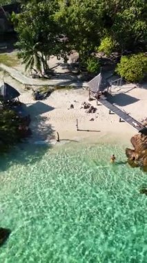 Işıldayan turkuaz sular, Tayland 'daki bu sakin plaj ortamında yumuşak kumlu kıyılarla buluşur. Ziyaretçiler Koh Munnork Adası 'nda rahatlama ve keşif yaparken yemyeşil palmiye ağaçları gölge sağlar.